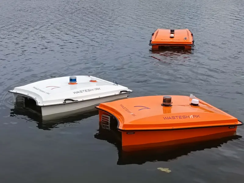 Orange and white WasteShark vessels on open water